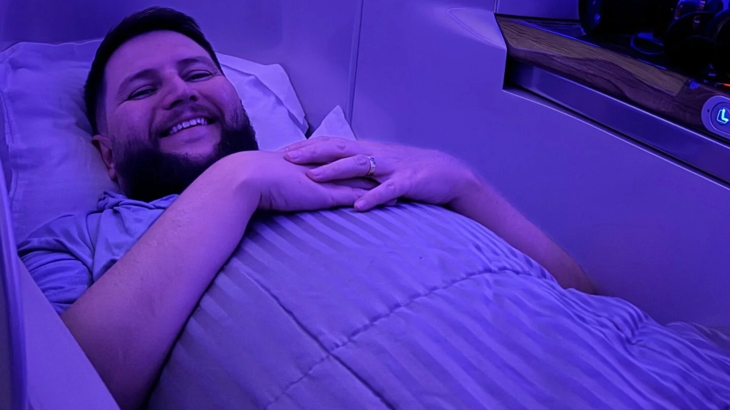Rudi deitado na cama plana da executiva do A380 da Emirates