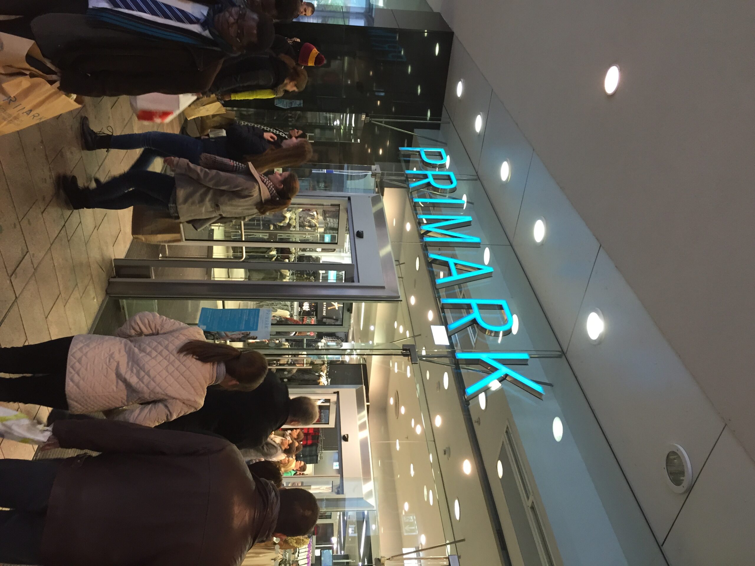 Entrada de uma loja da Primark com clientes circulando
