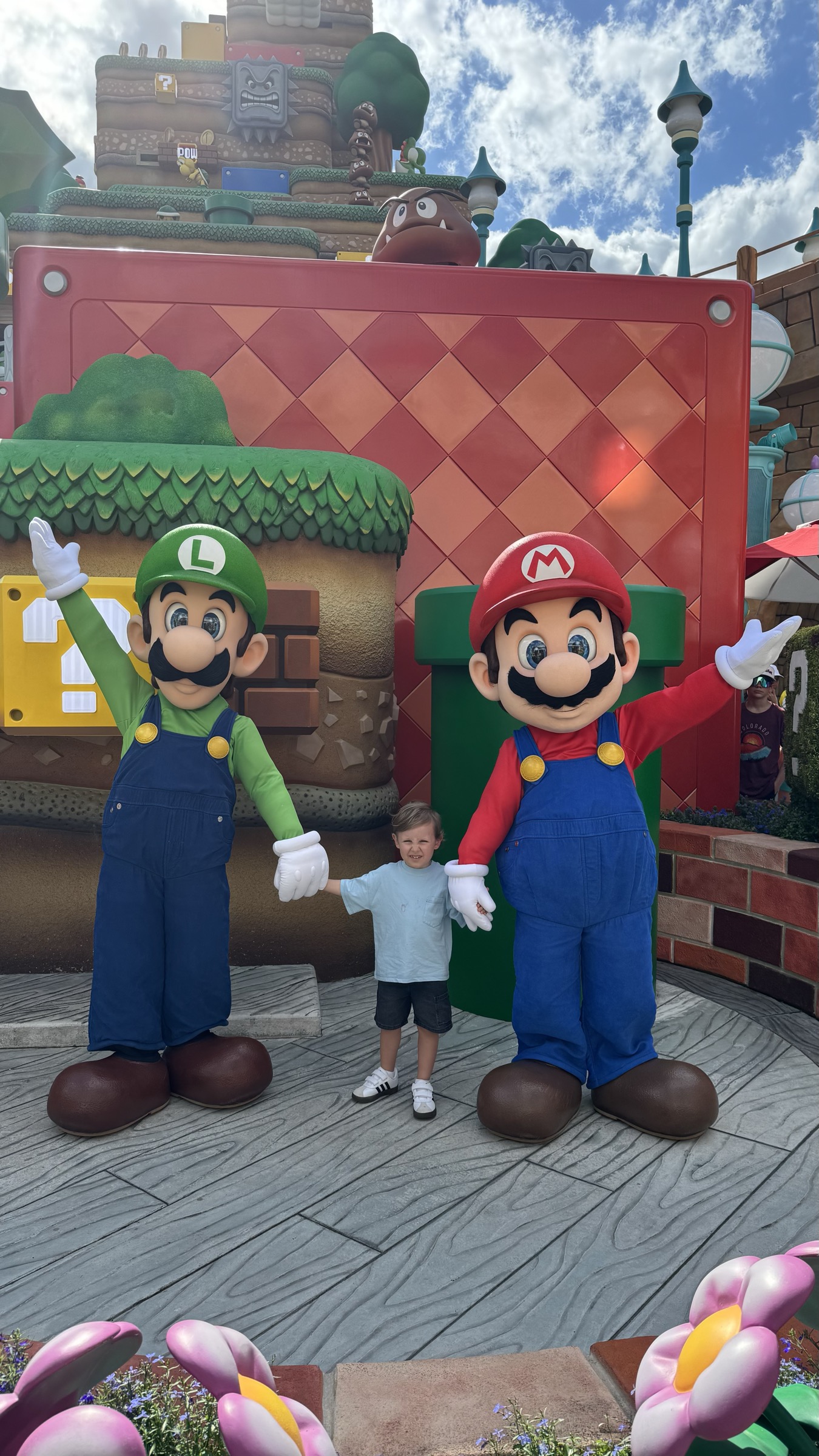 Familia posando com os personagens Mario e Luigi no Super Nintendo World do Epic Universe