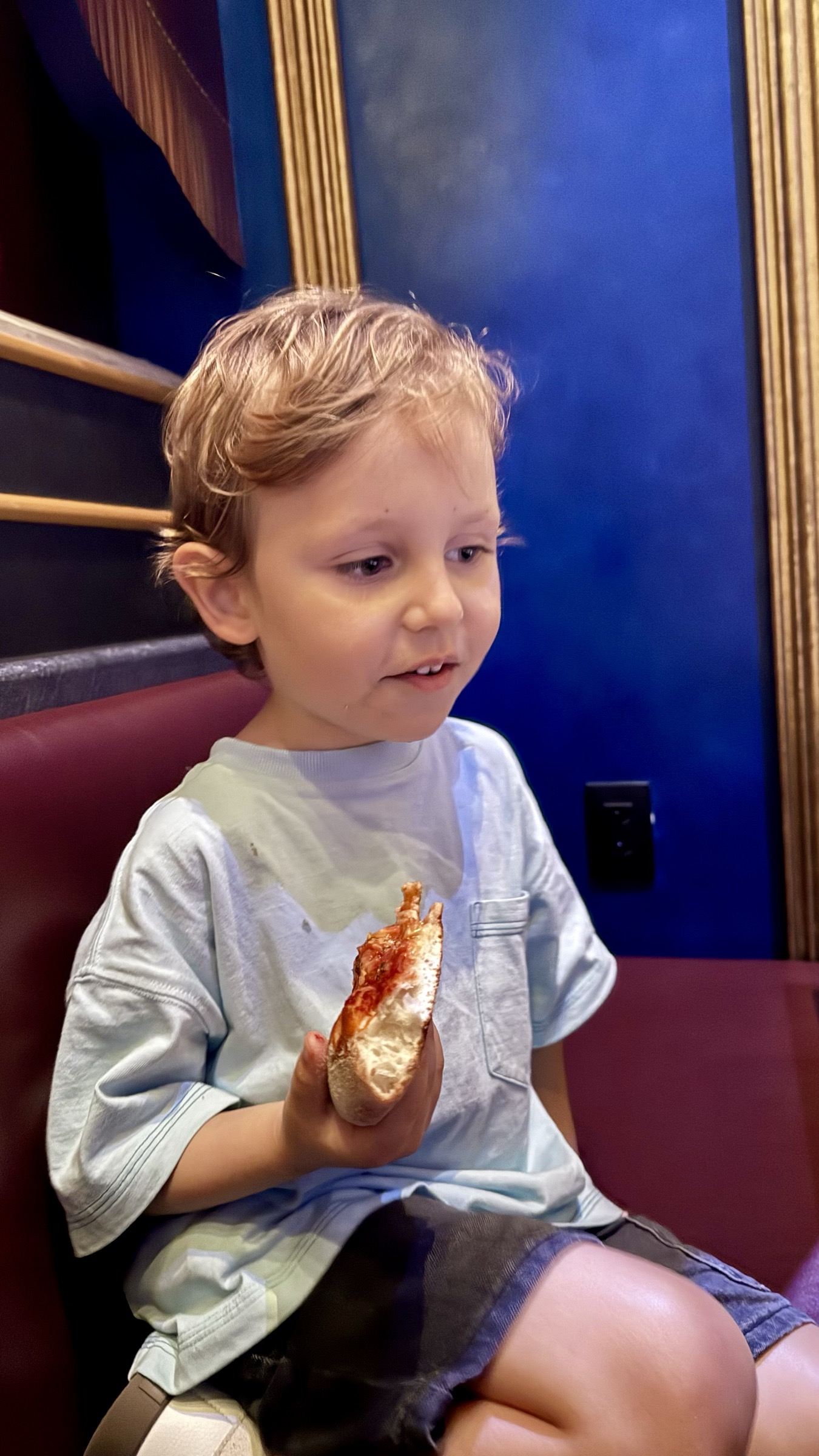 Samuel sentado comendo seu prato infantil no interior do Toadstool Cafe no Super Nintendo World