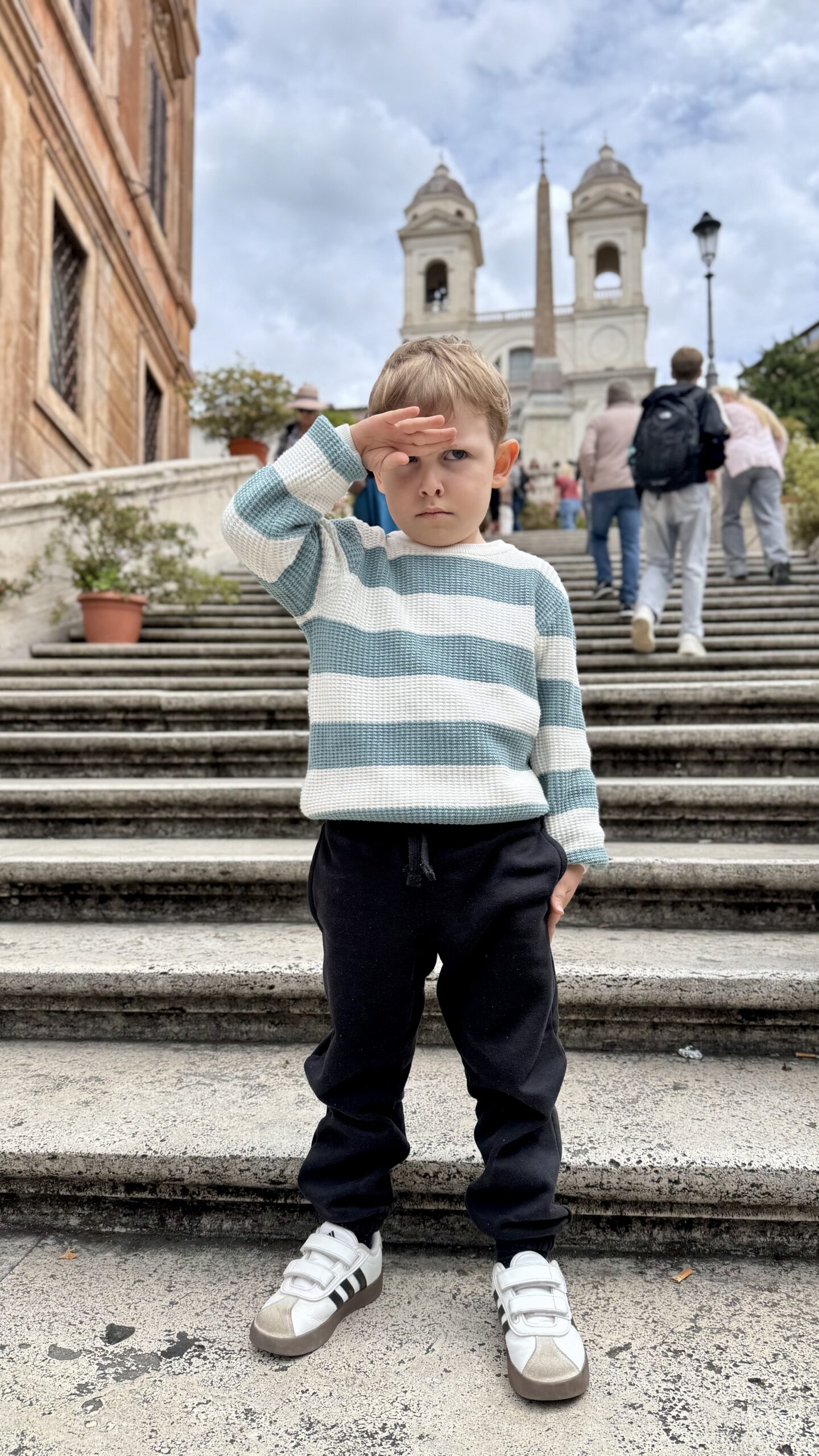 Criança na Escadaria Espanhola, com as torres da igreja de Trinità dei Monti ao fundo.
