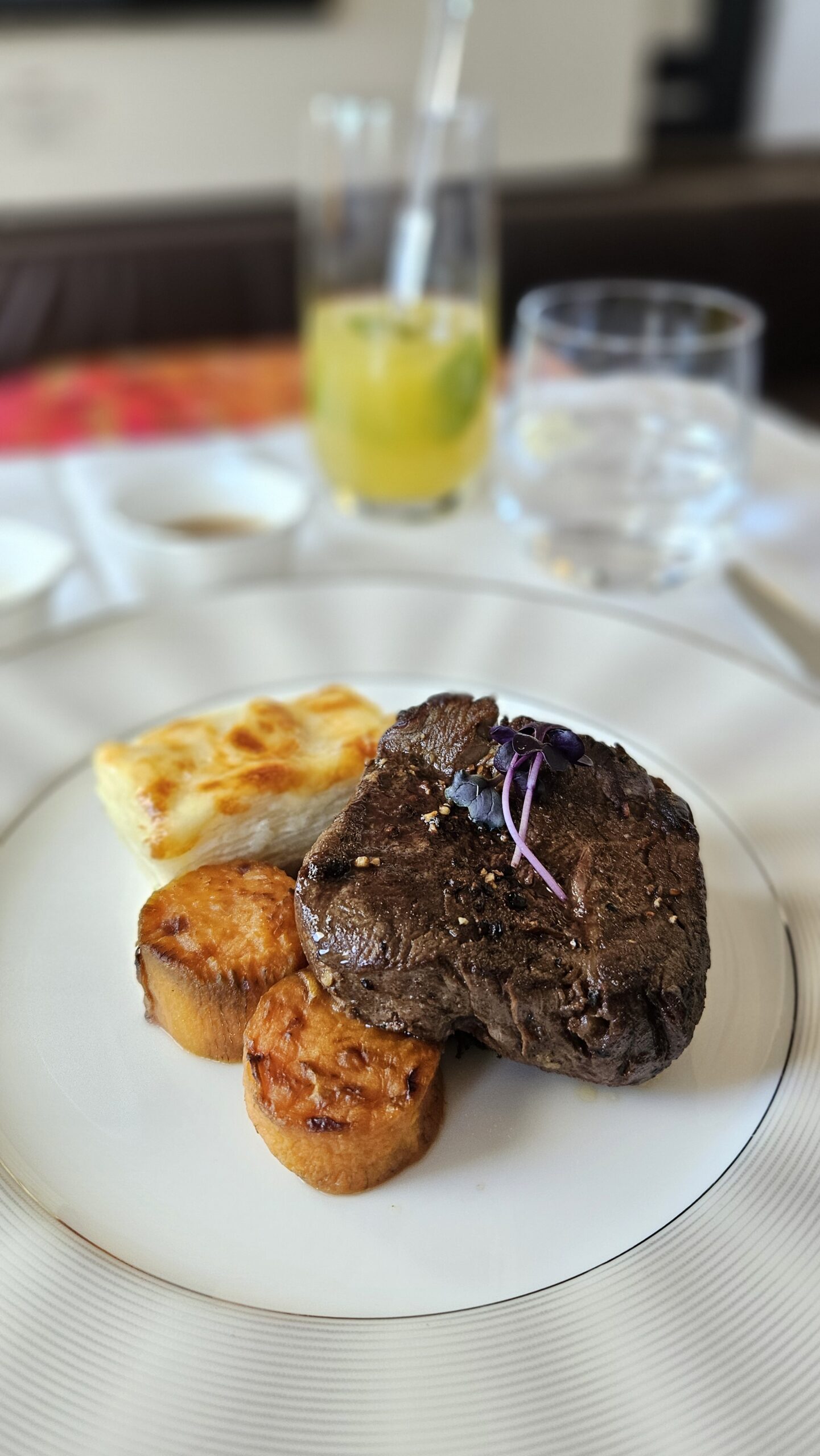 Prato de filé com molho, pão e acompanhamentos servido na Primeira Classe da Etihad no A380