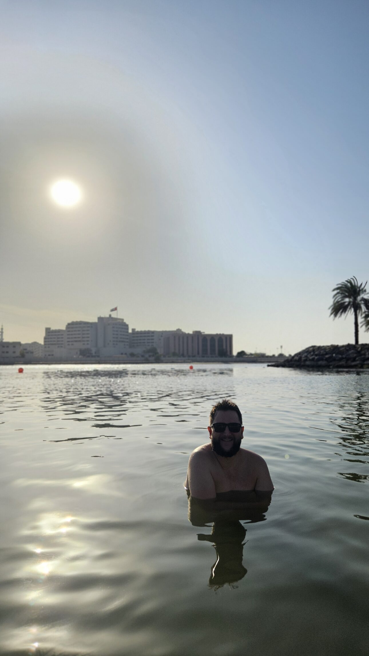 Rudi na piscina do Fairmont Abu Dhabi com a vista da cidade ao fundo