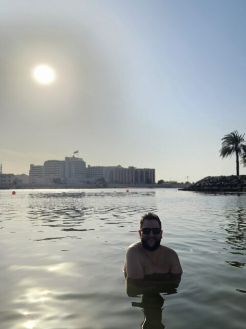 Rudi na piscina do Fairmont Abu Dhabi com a vista da cidade ao fundo