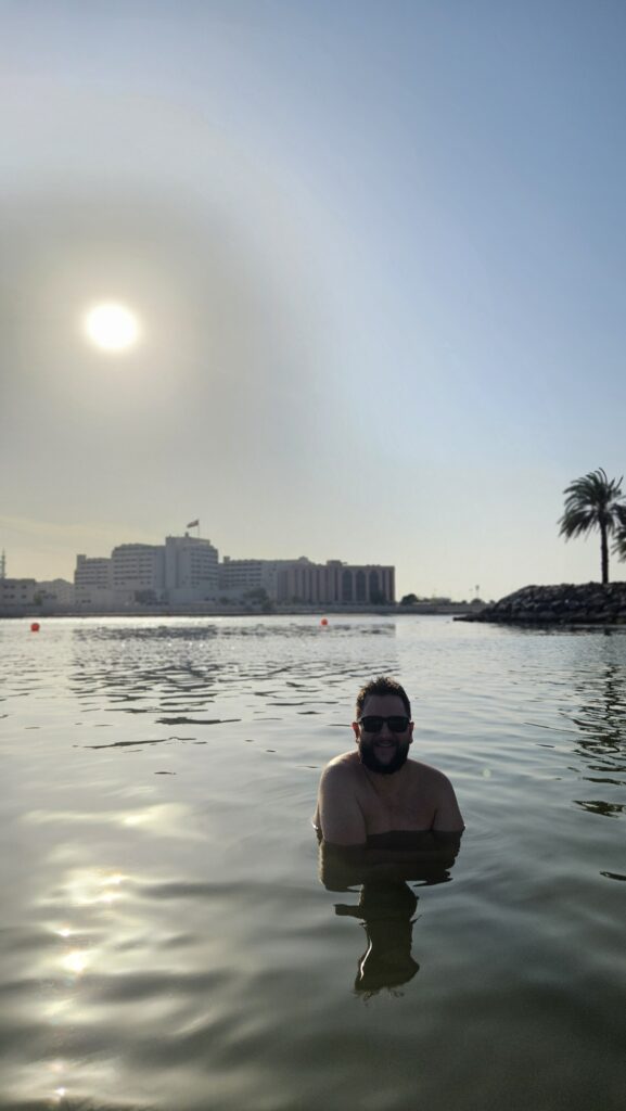 Rudi na piscina do Fairmont Abu Dhabi com a vista da cidade ao fundo