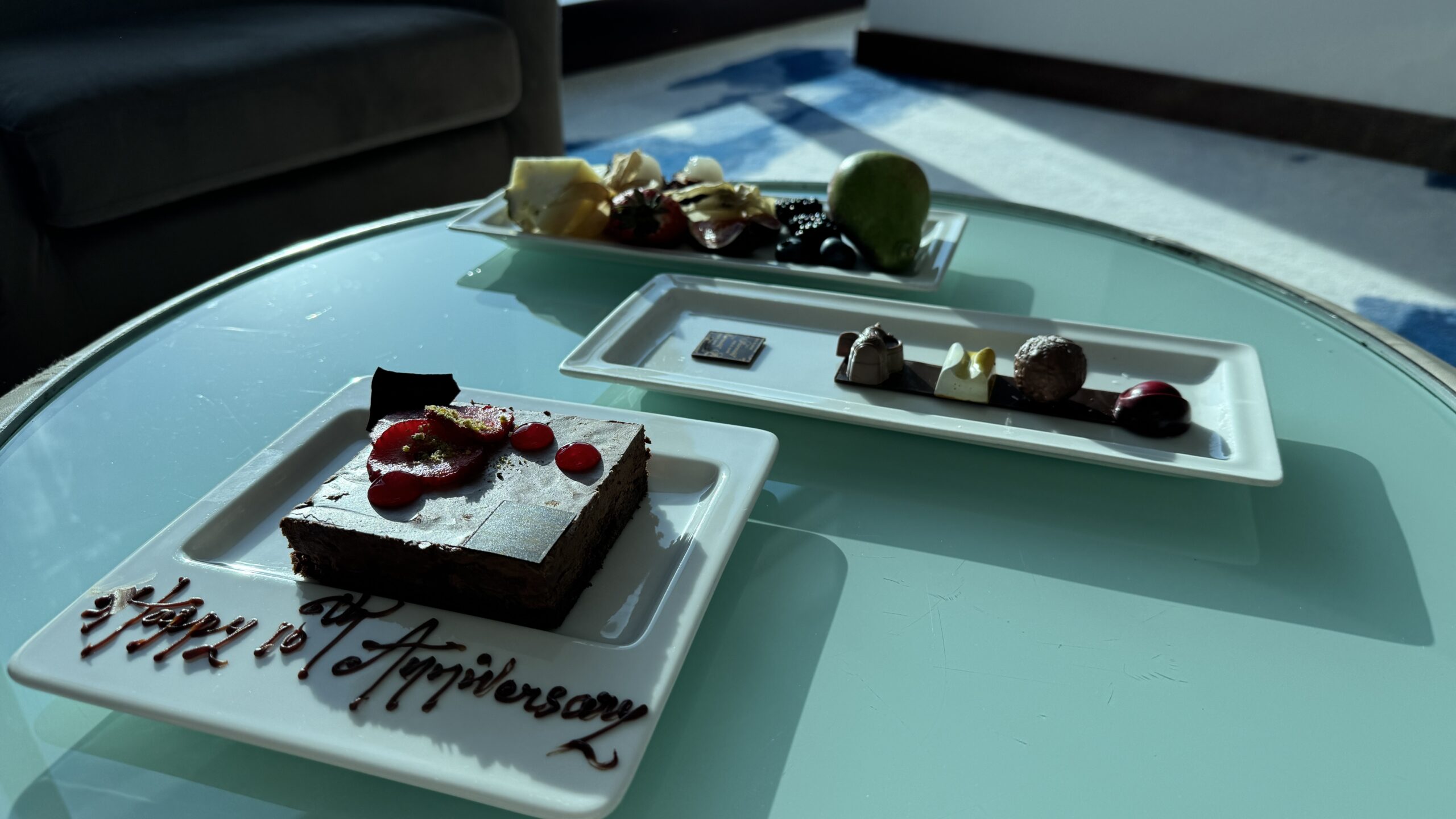 Mesa de centro da suíte do Fairmont Bab Al Bahr com bolo, docinhos e frutas de cortesia