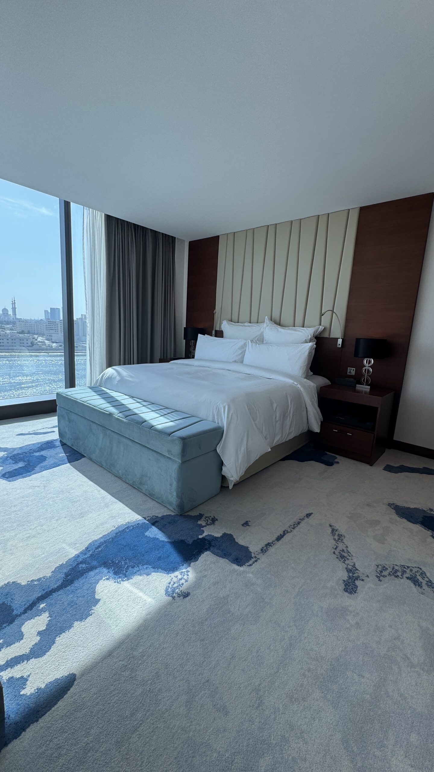 Quarto da suíte do Fairmont Bab Al Bahr com cama king size e vista para o mar artificial