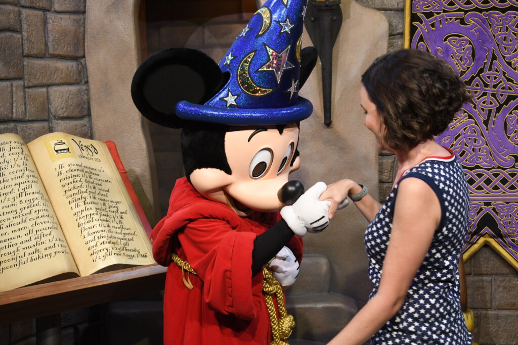 Mulher cumprimentando o Mickey Feiticeiro em encontro de personagem no Hollywood Studios, Orlando