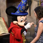 Mulher cumprimentando o Mickey Feiticeiro em encontro de personagem no Hollywood Studios, Orlando