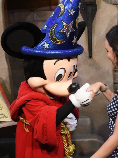 Mulher cumprimentando o Mickey Feiticeiro em encontro de personagem no Hollywood Studios, Orlando