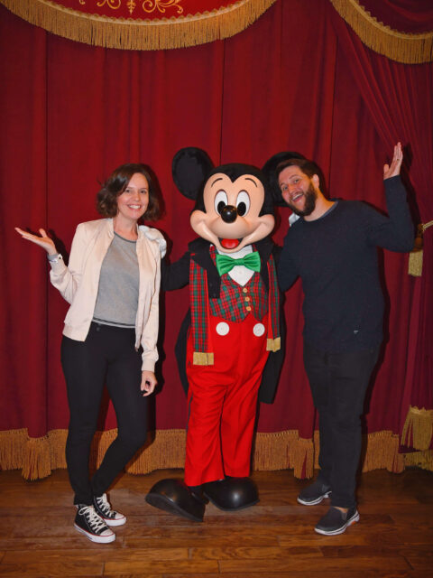 Casal posa com o Mickey vestido a rigor durante festa natalina exclusiva no Magic Kingdom
