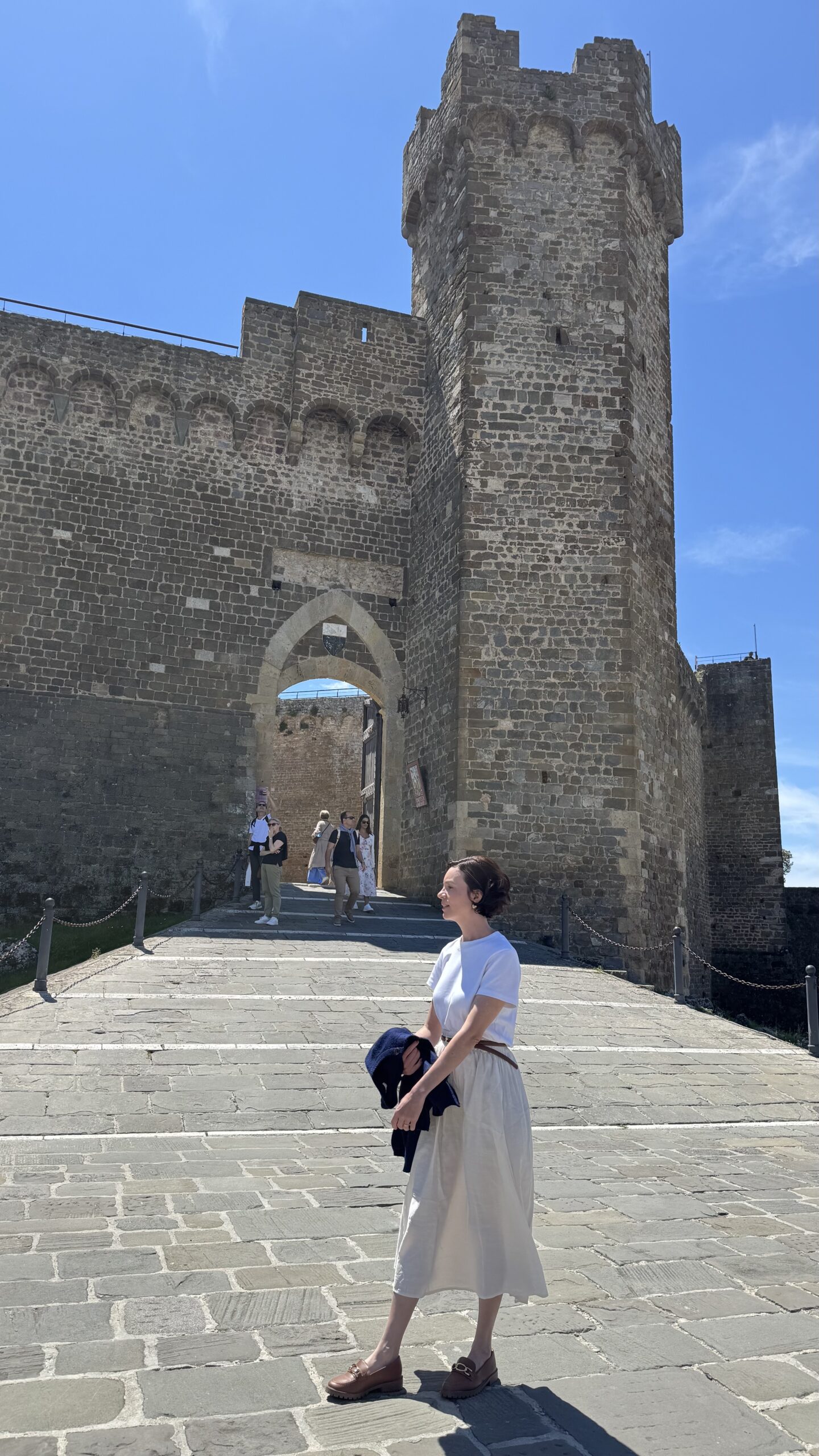 Muralhas e torre da Fortezza de Montalcino sob céu azul