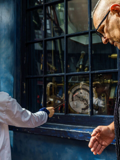 Pai e filho testam varinha interativa em vitrine de loja em Hogsmeade, na Universal Islands of Adventure