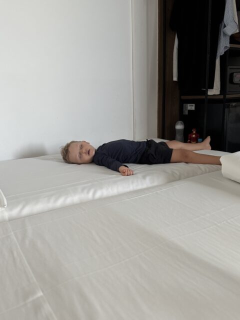 Samuel dormindo na cama extra do quarto do Ibis Styles Maceió Pajuçara