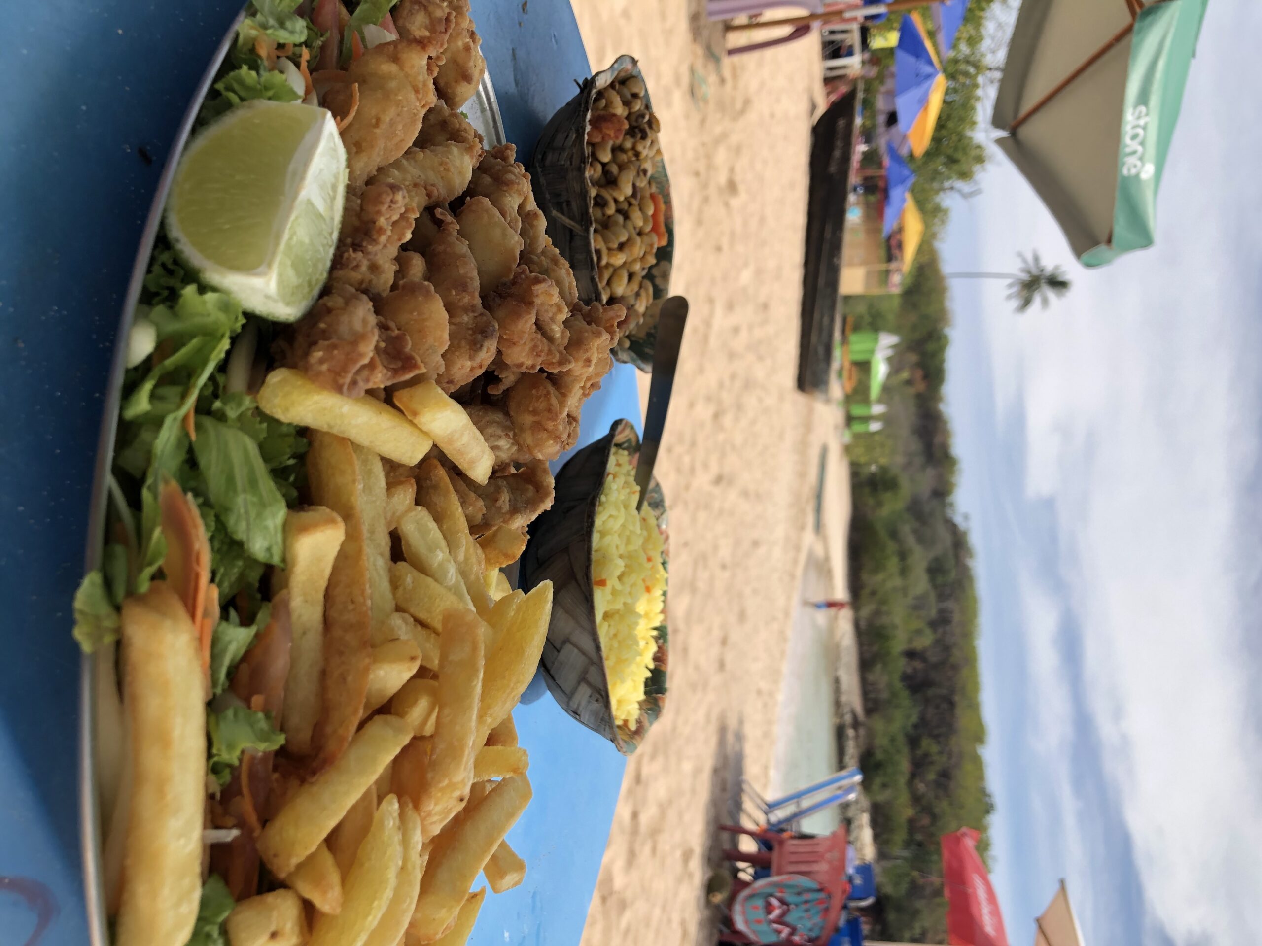 Prato de isca de peixe com arroz, feijão tropeiro e batata frita servido na praia da Ilha de Santo Aleixo.