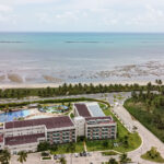 Vista aérea de drone do Japaratinga Lounge Resort com piscinas e praia