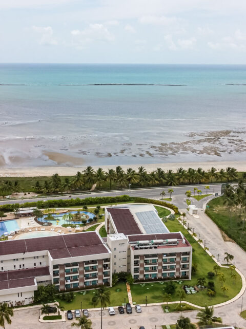 Vista aérea de drone do Japaratinga Lounge Resort com piscinas e praia