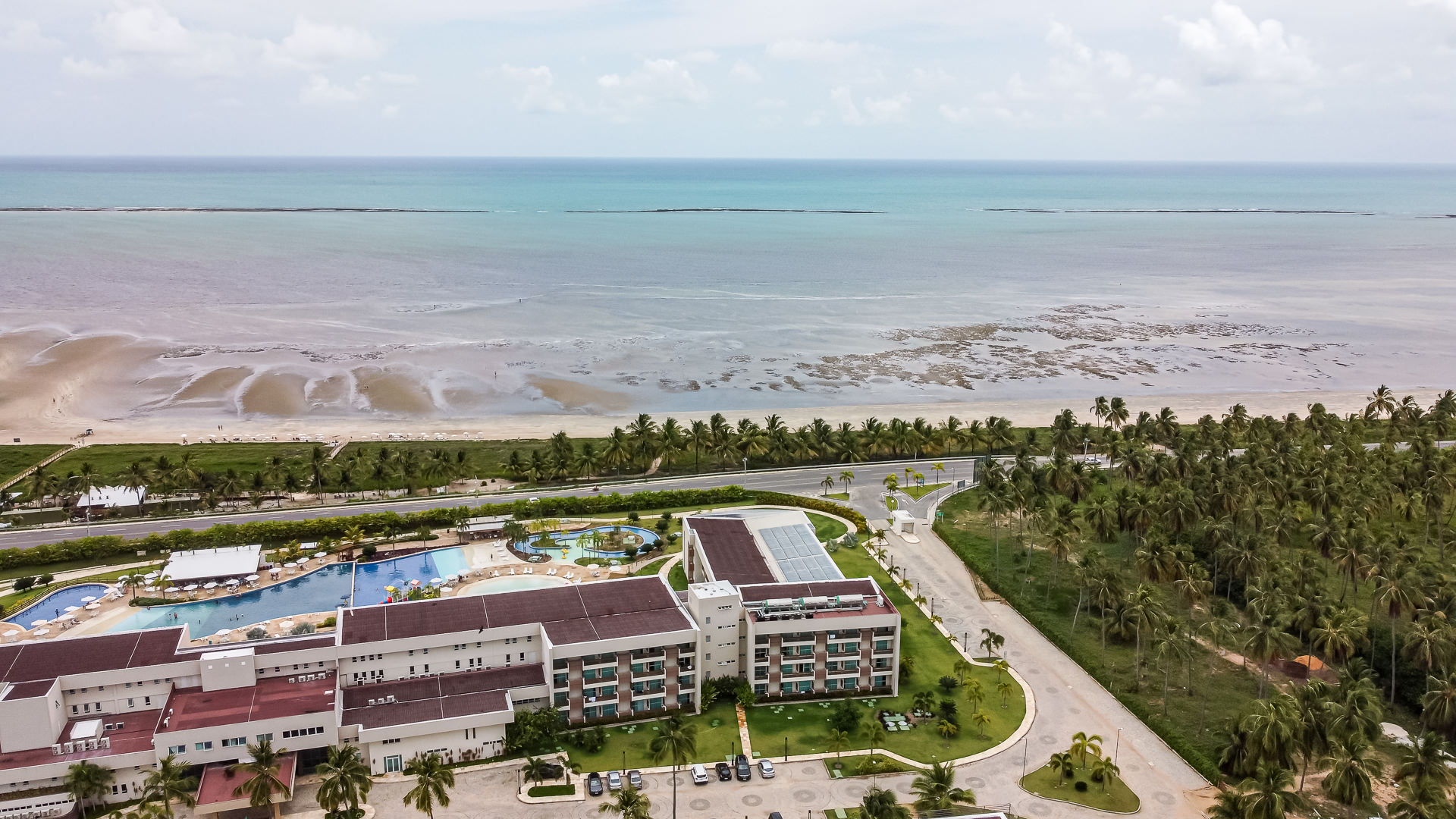 Vista aérea de drone do Japaratinga Lounge Resort com piscinas e praia