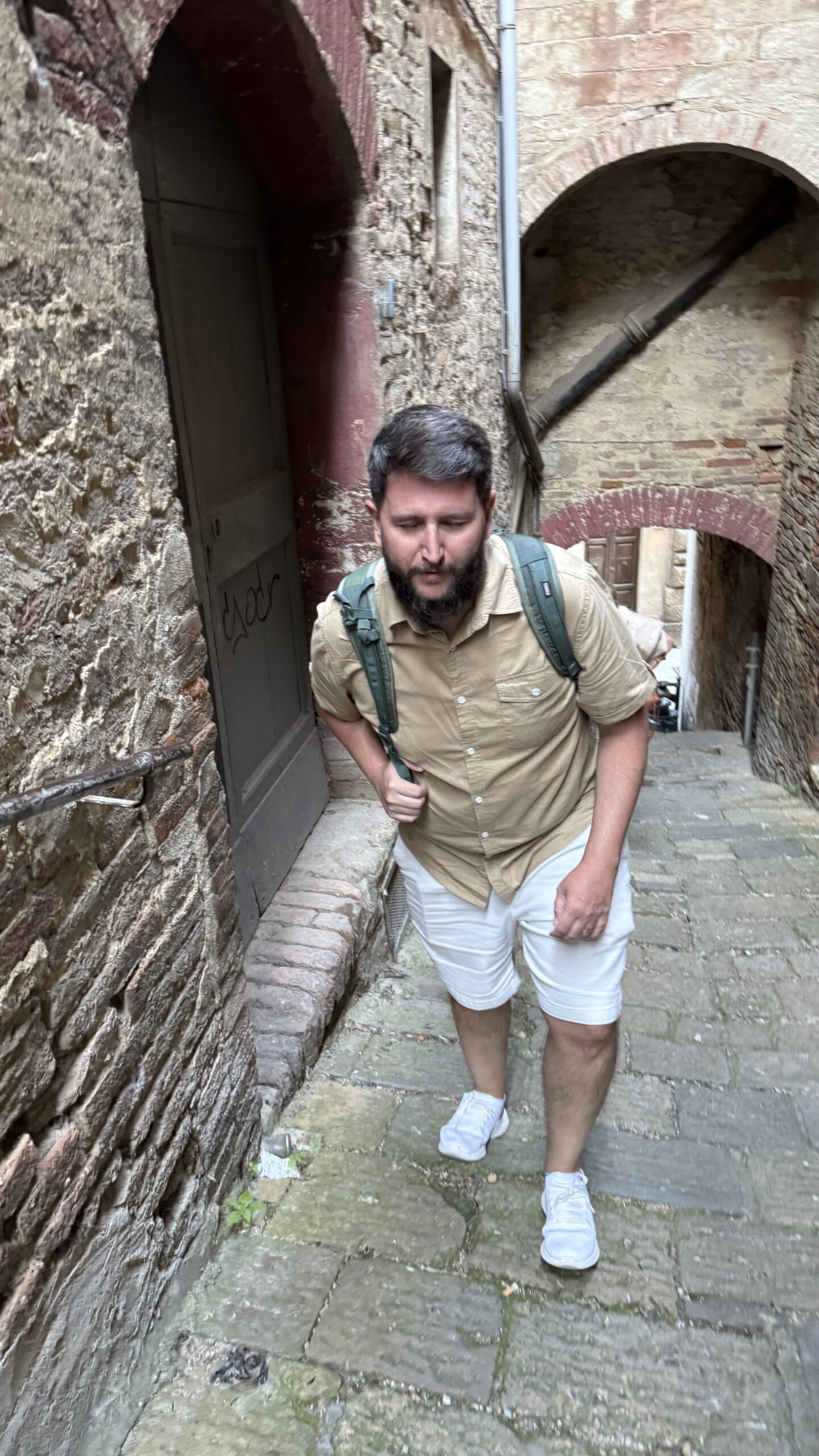 Criança subindo ladeira de pedra estreita em Montepulciano