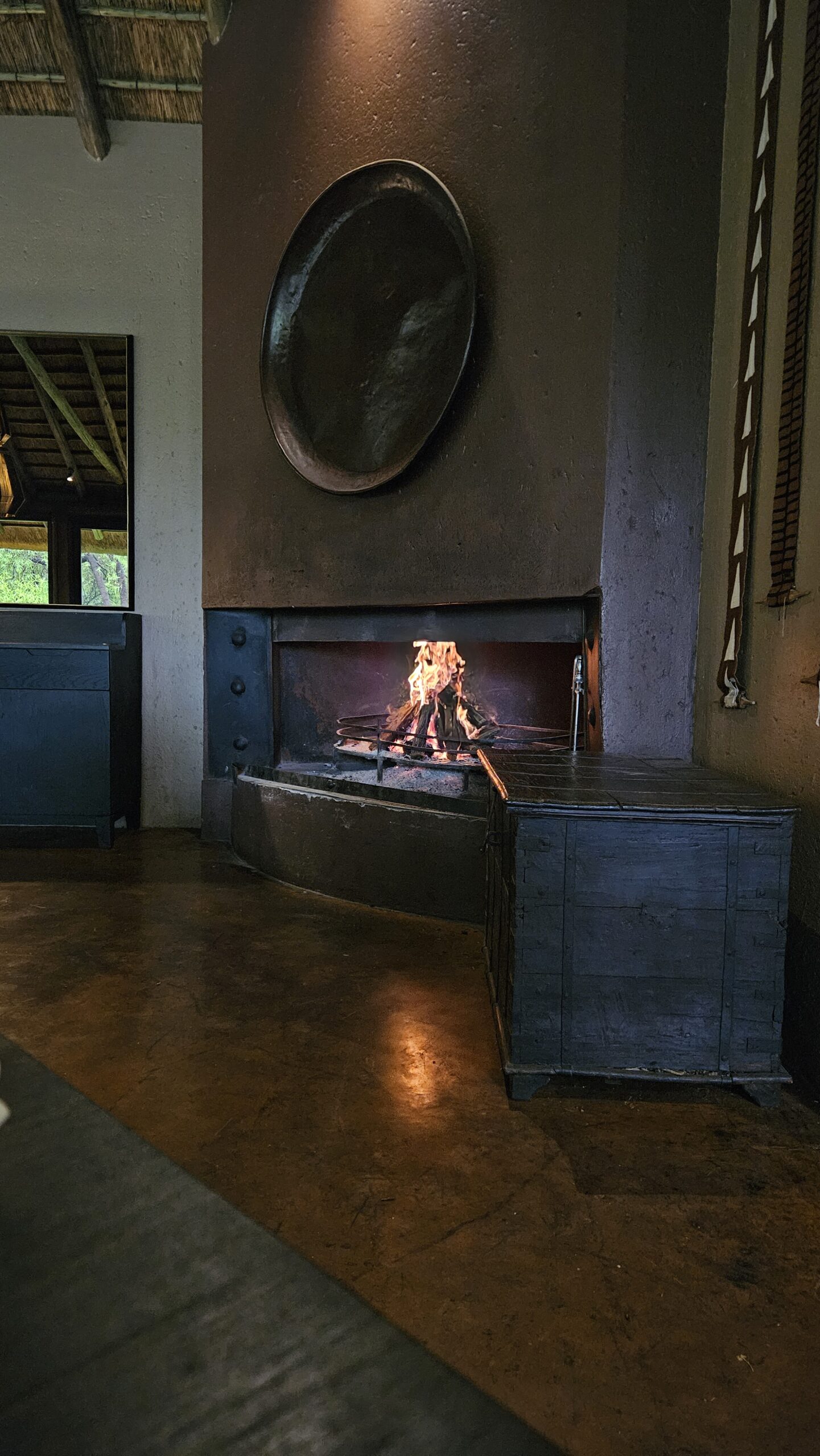 Lareira acesa dentro do restaurante do Letamo Lodge, estilo braai sul-africano