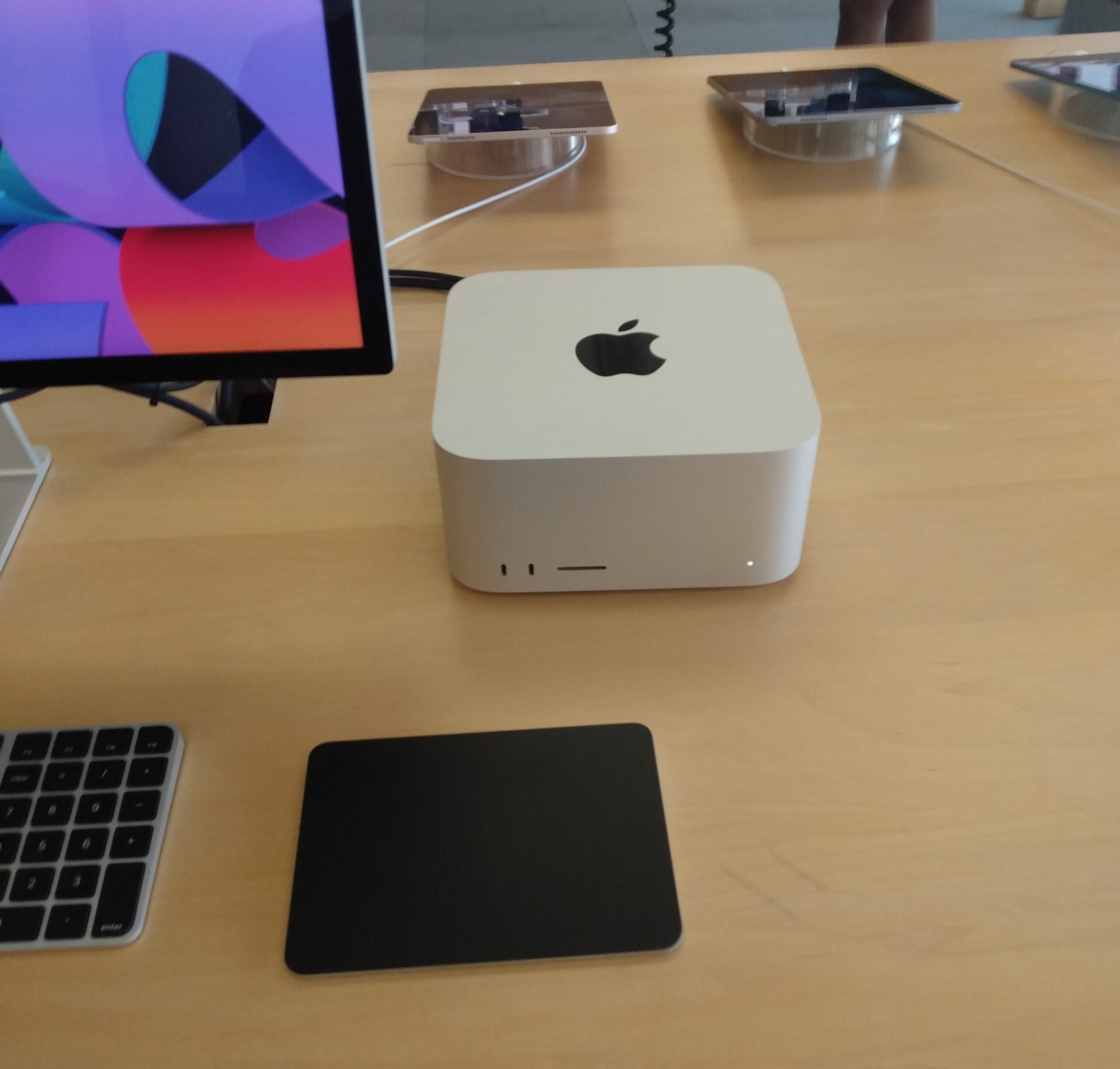 Mac Studio e acessórios Apple expostos em uma mesa de loja física