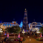 Main Street USA decorada para o Natal à noite no Magic Kingdom, com árvore de Natal iluminada e o castelo ao fundo