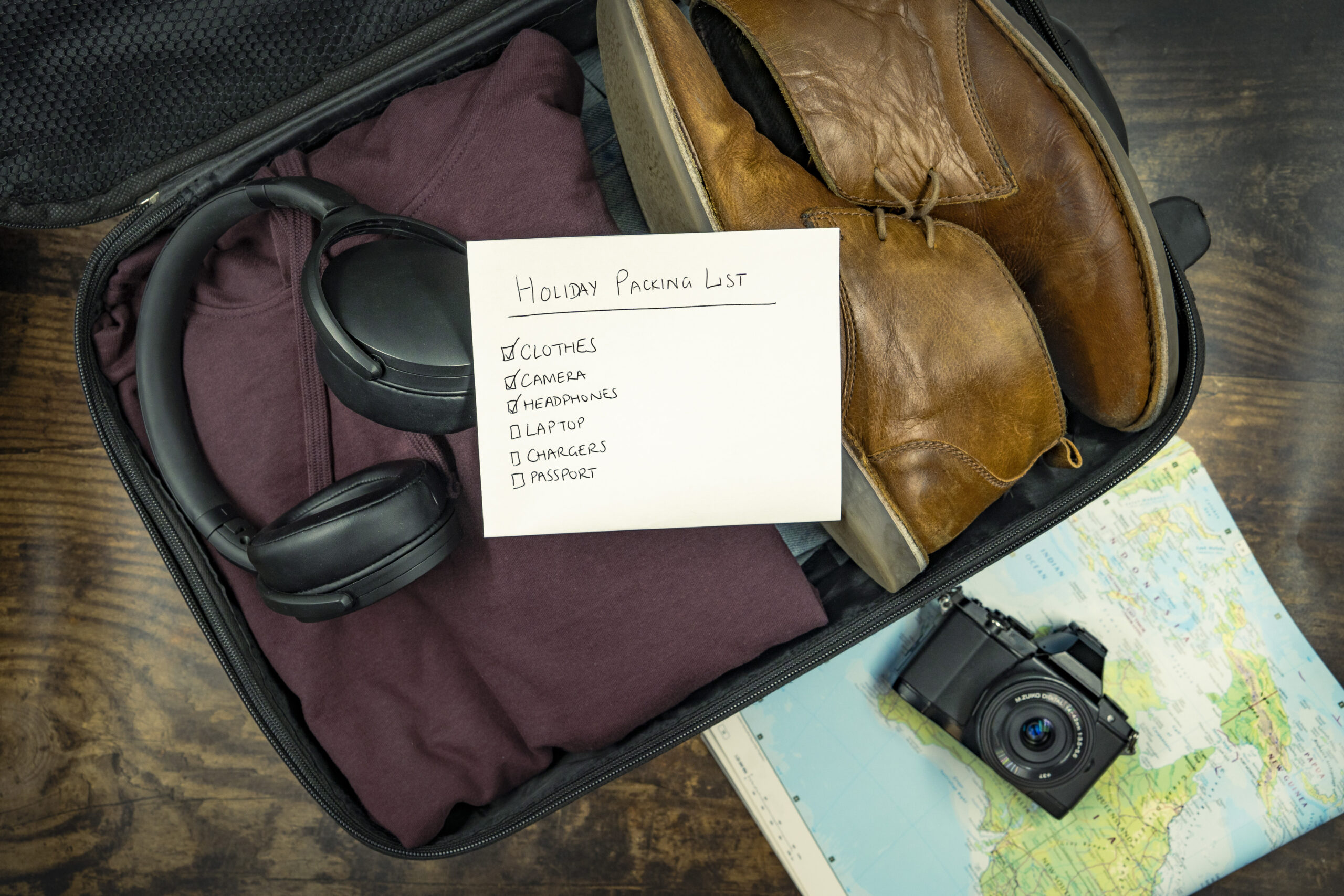 Mala aberta com checklist de viagem, ilustrando organizacao do enxoval de bebe para a viagem