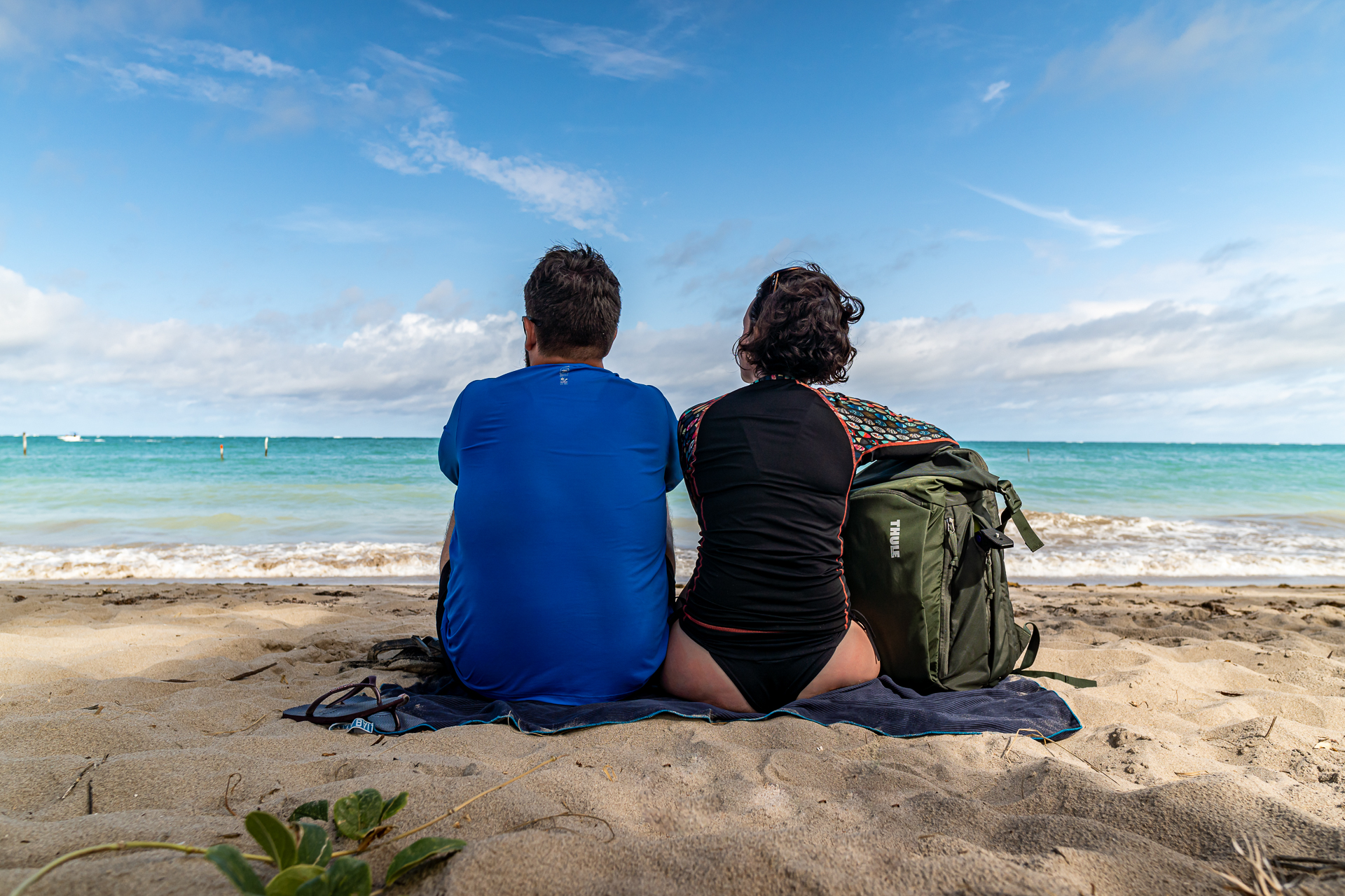 Casal sentado na areia observando o mar em uma das praias de Maragogi