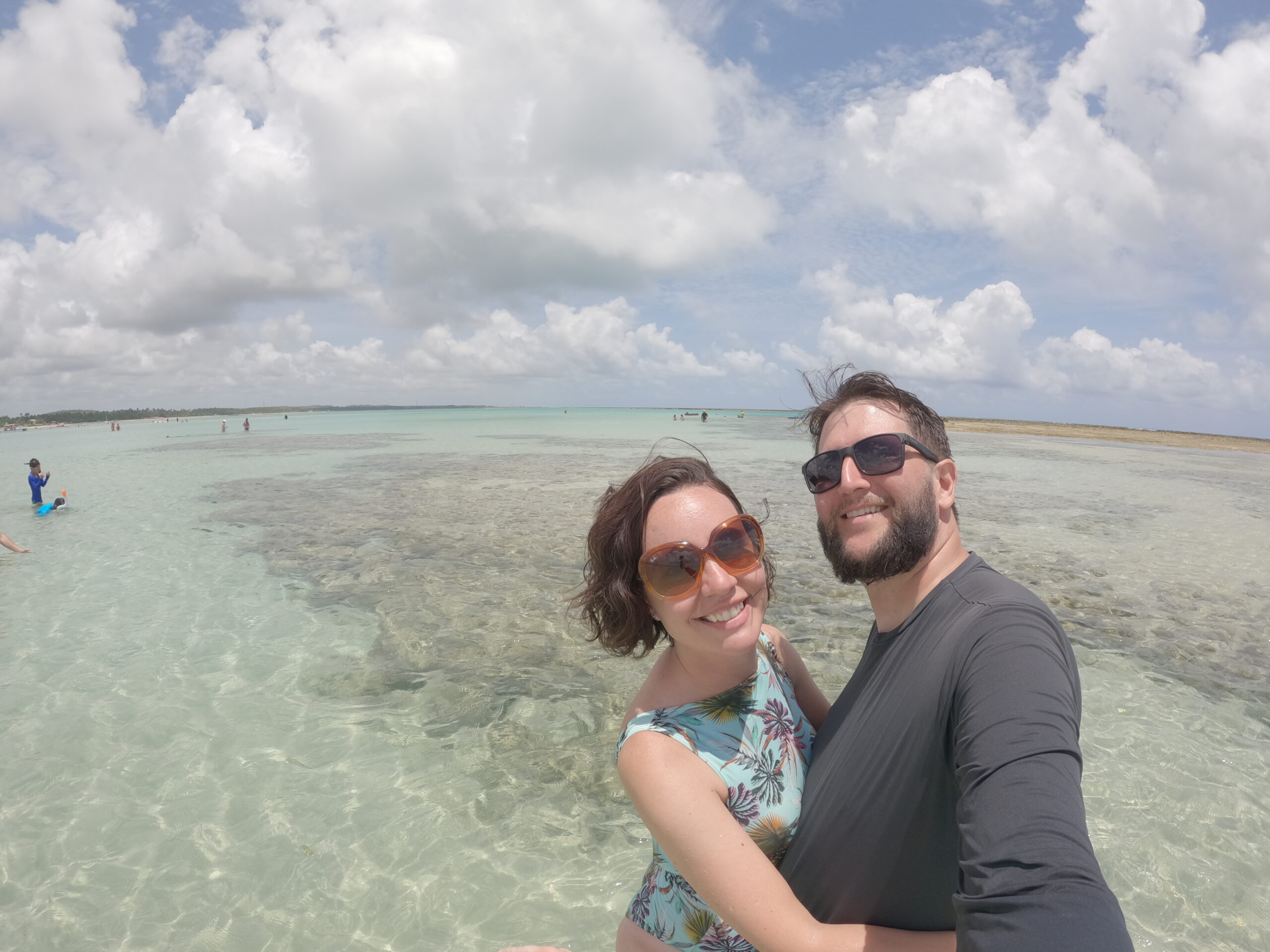 Casal sorrindo dentro de piscina natural transparente em Maragogi