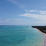 Vista aerea da orla de Maragogi com agua azul turquesa e recifes visiveis na maré baixa