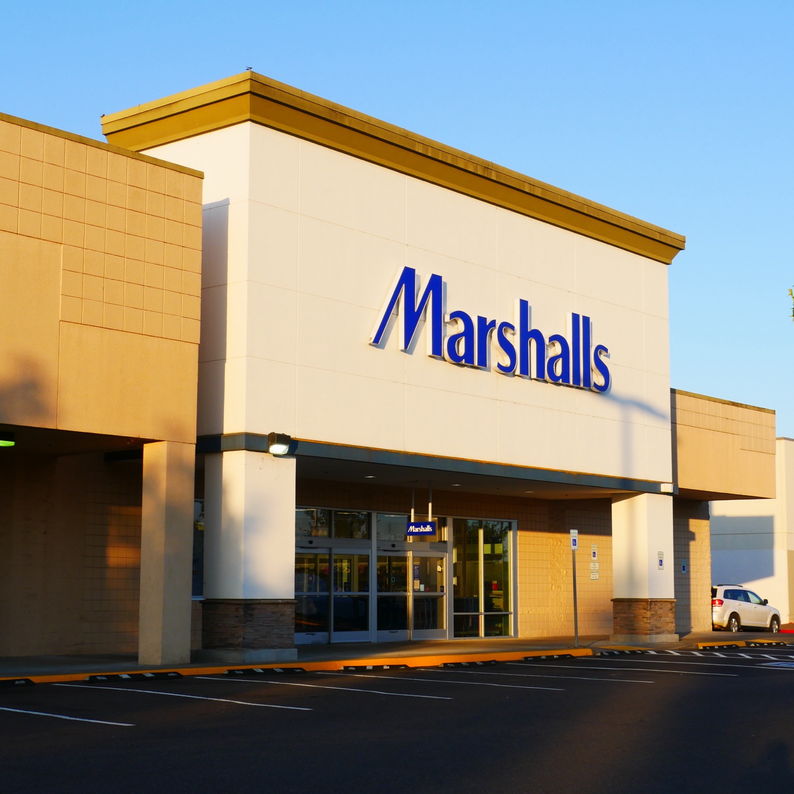 Fachada de uma loja Marshalls com estacionamento vazio no fim de tarde