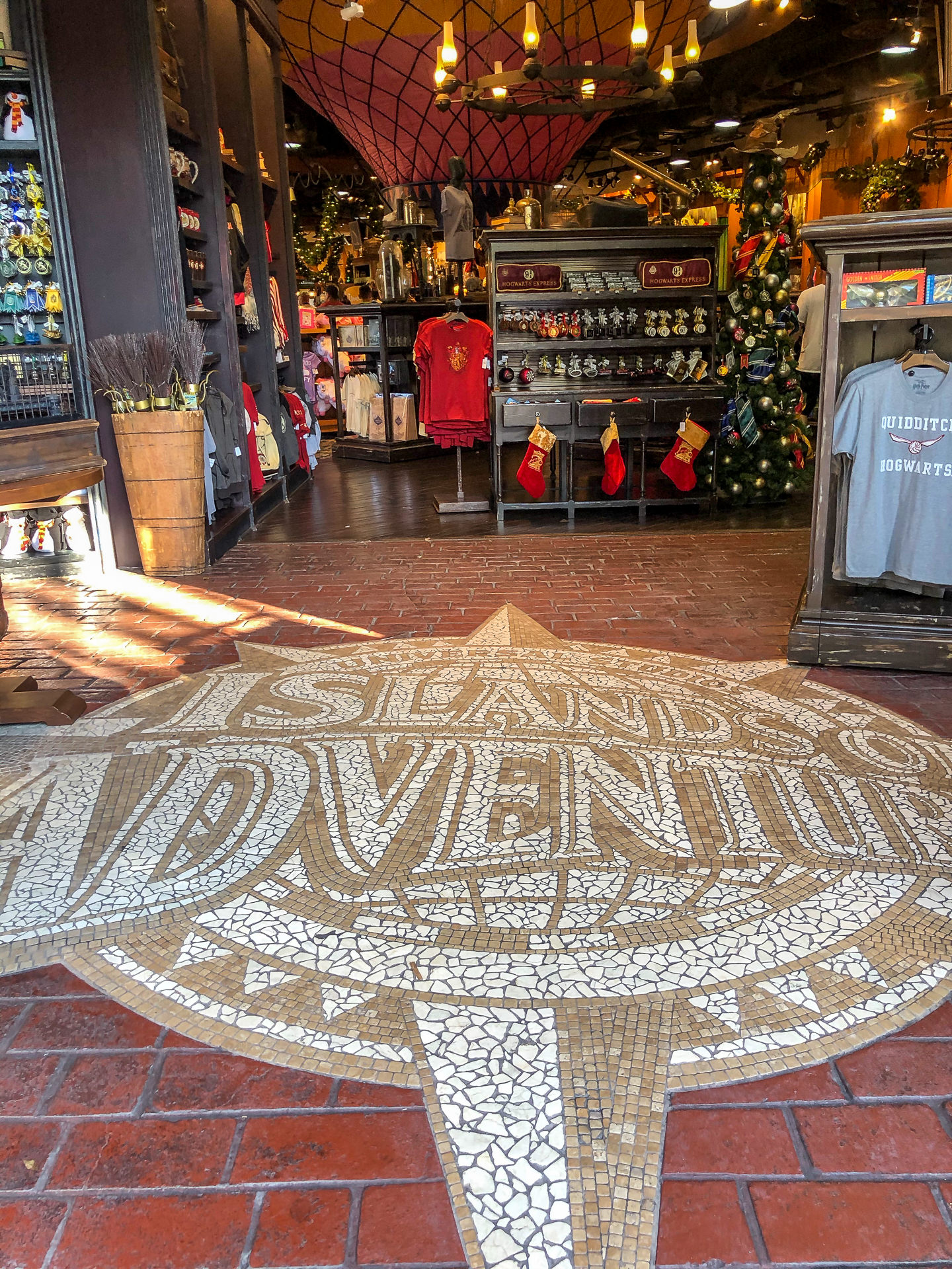Mosaico de piso com o nome Islands of Adventure na entrada de uma loja tematica de Harry Potter