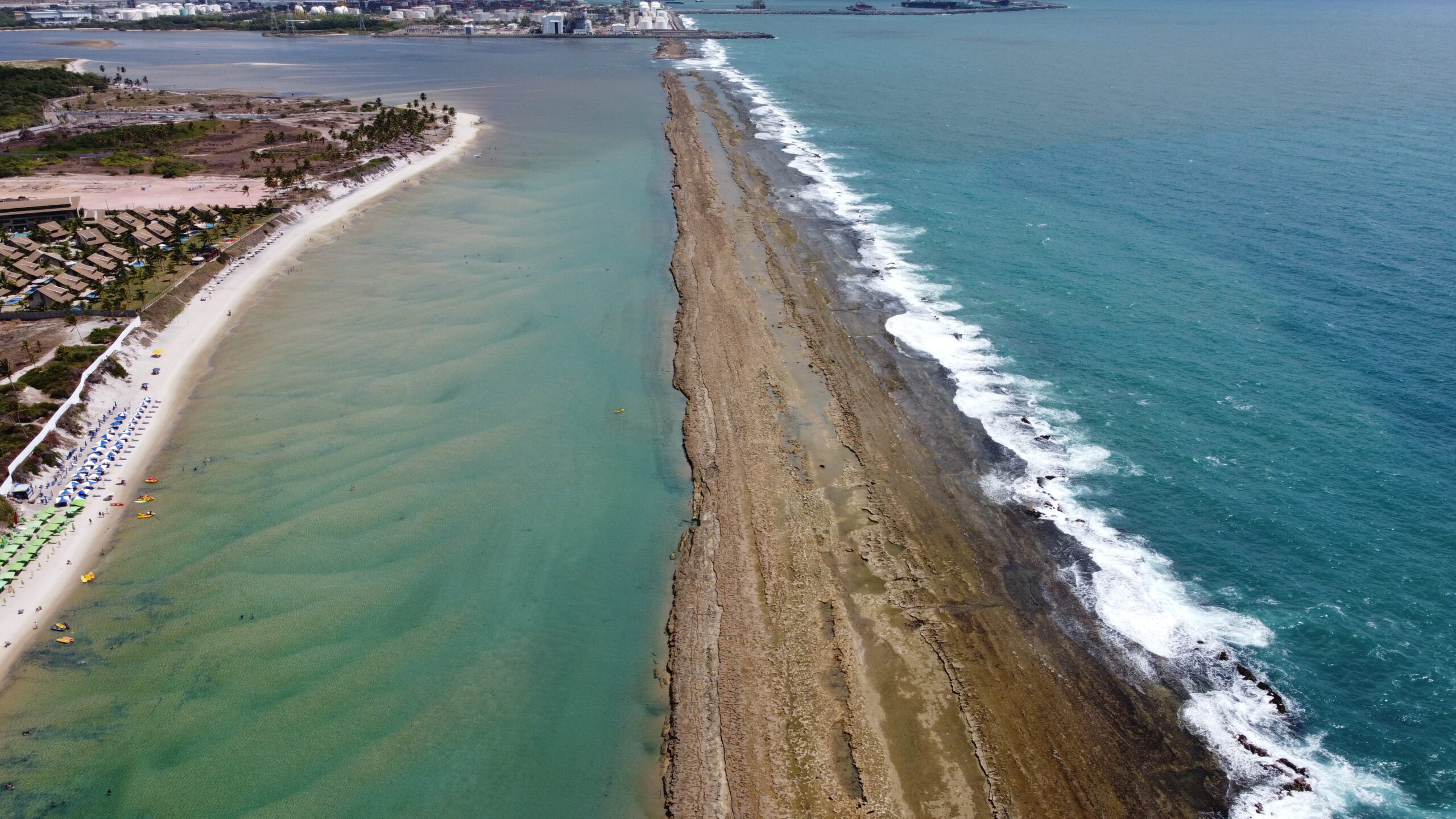 Vista aerea da barreira de recifes e da piscina natural de Muro Alto, Pernambuco, em tons de verde e azul
