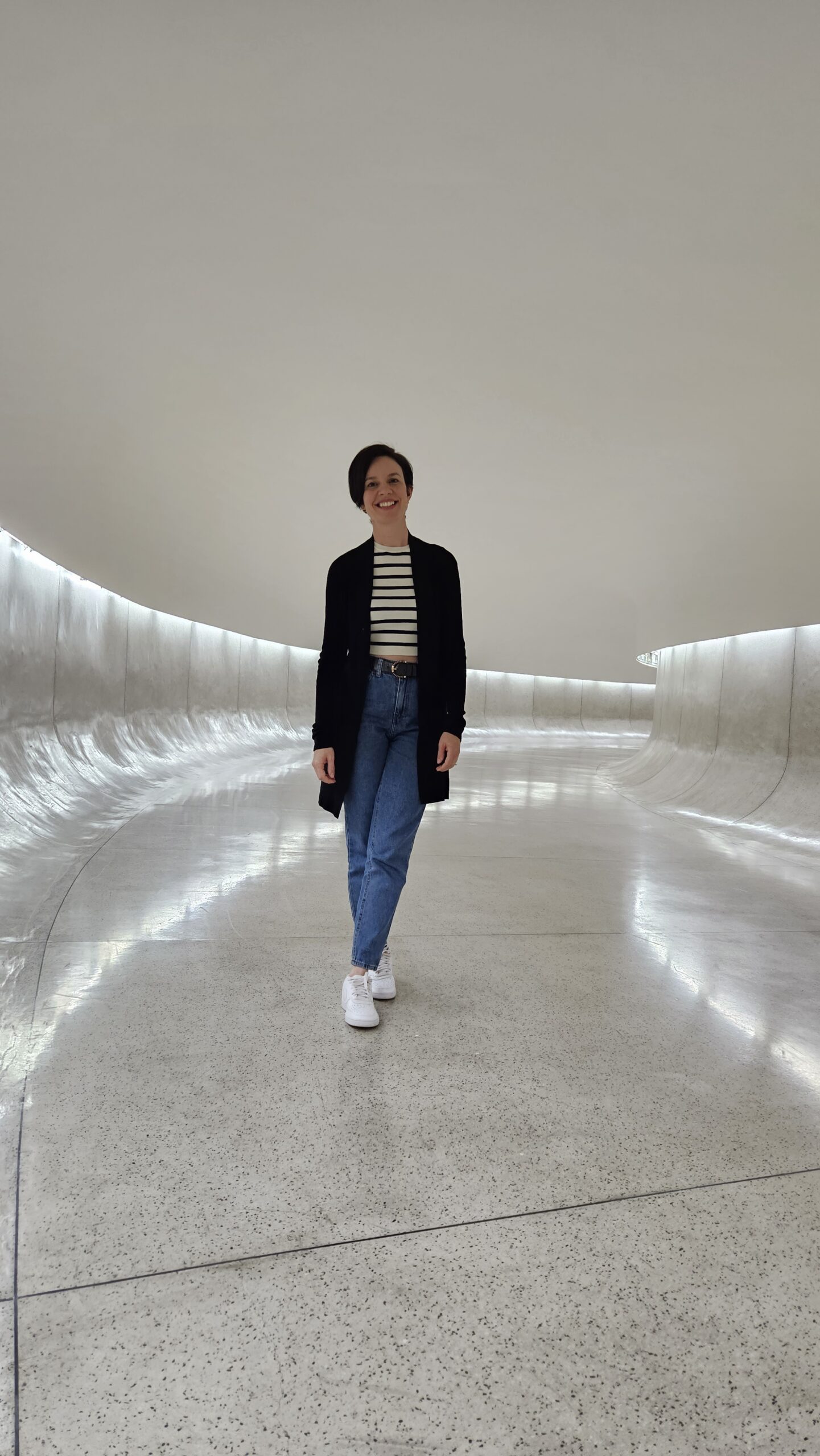 Rampa curva de concreto branco dentro do Museu Oscar Niemeyer, o Museu do Olho, em Curitiba