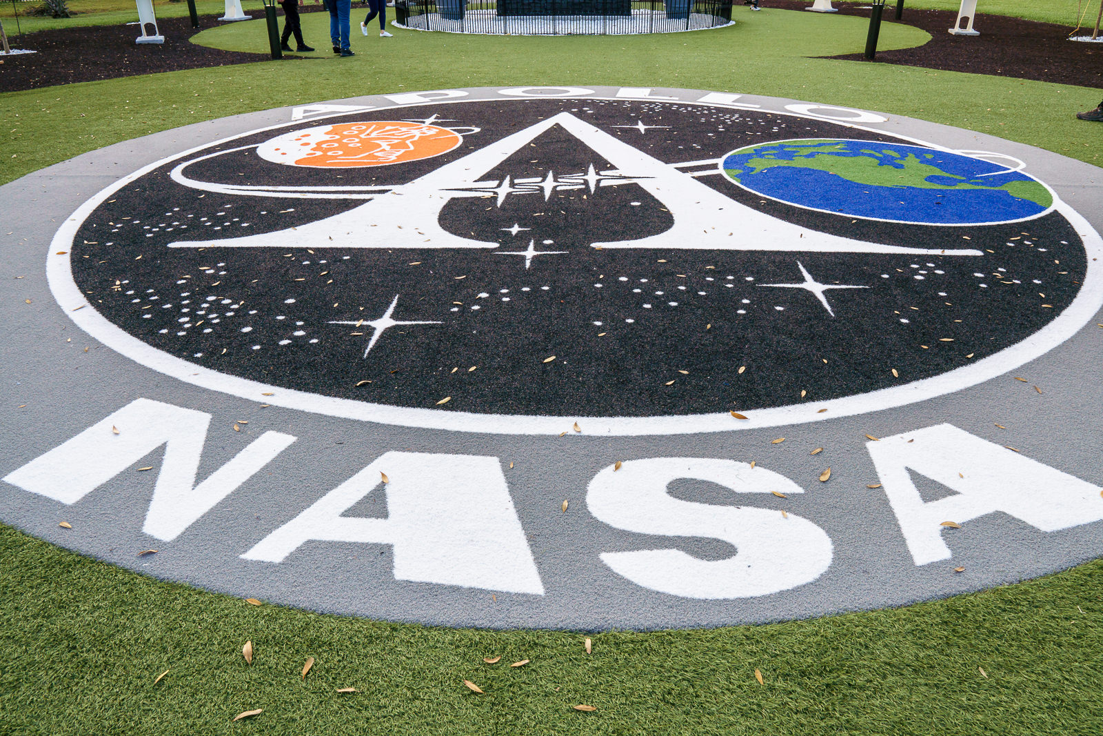 Logo da missão Apollo e da NASA pintado no chão do jardim externo do Kennedy Space Center