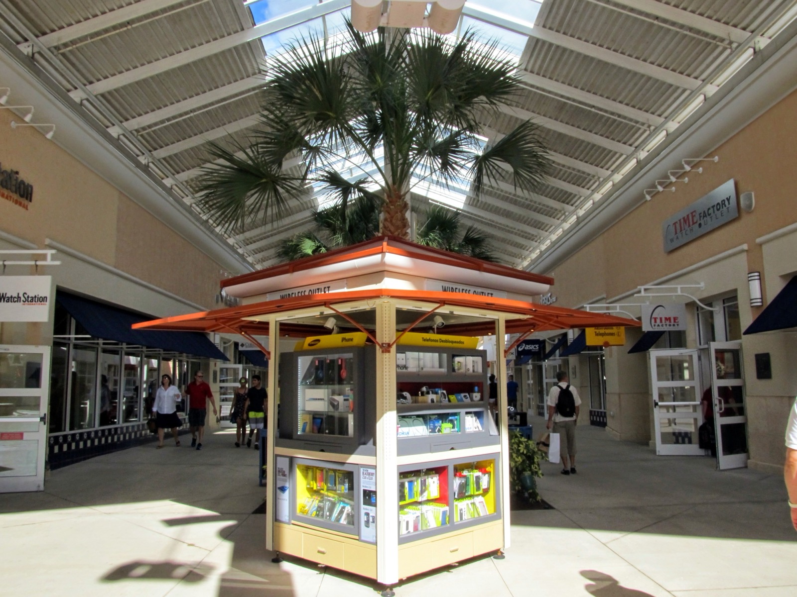 Corredor coberto de outlet em Orlando com quiosque central e poucas pessoas