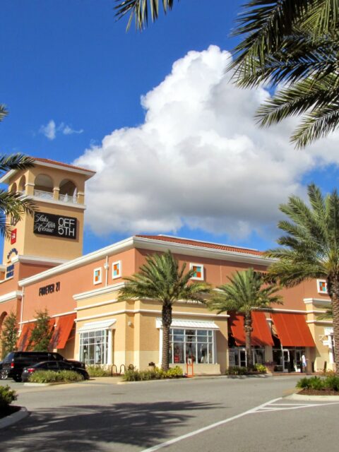 Fachada do Orlando Premium Outlets com lojas e palmeiras