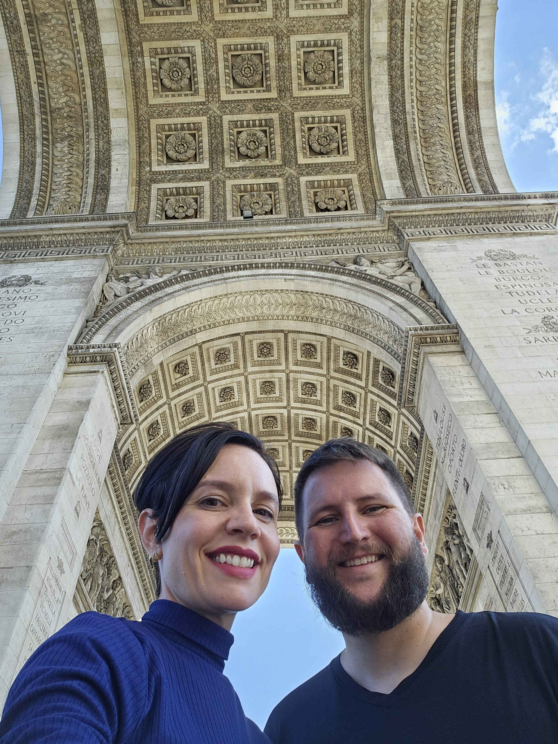 Casal com o bebê no colo em frente ao Arco do Triunfo em Paris