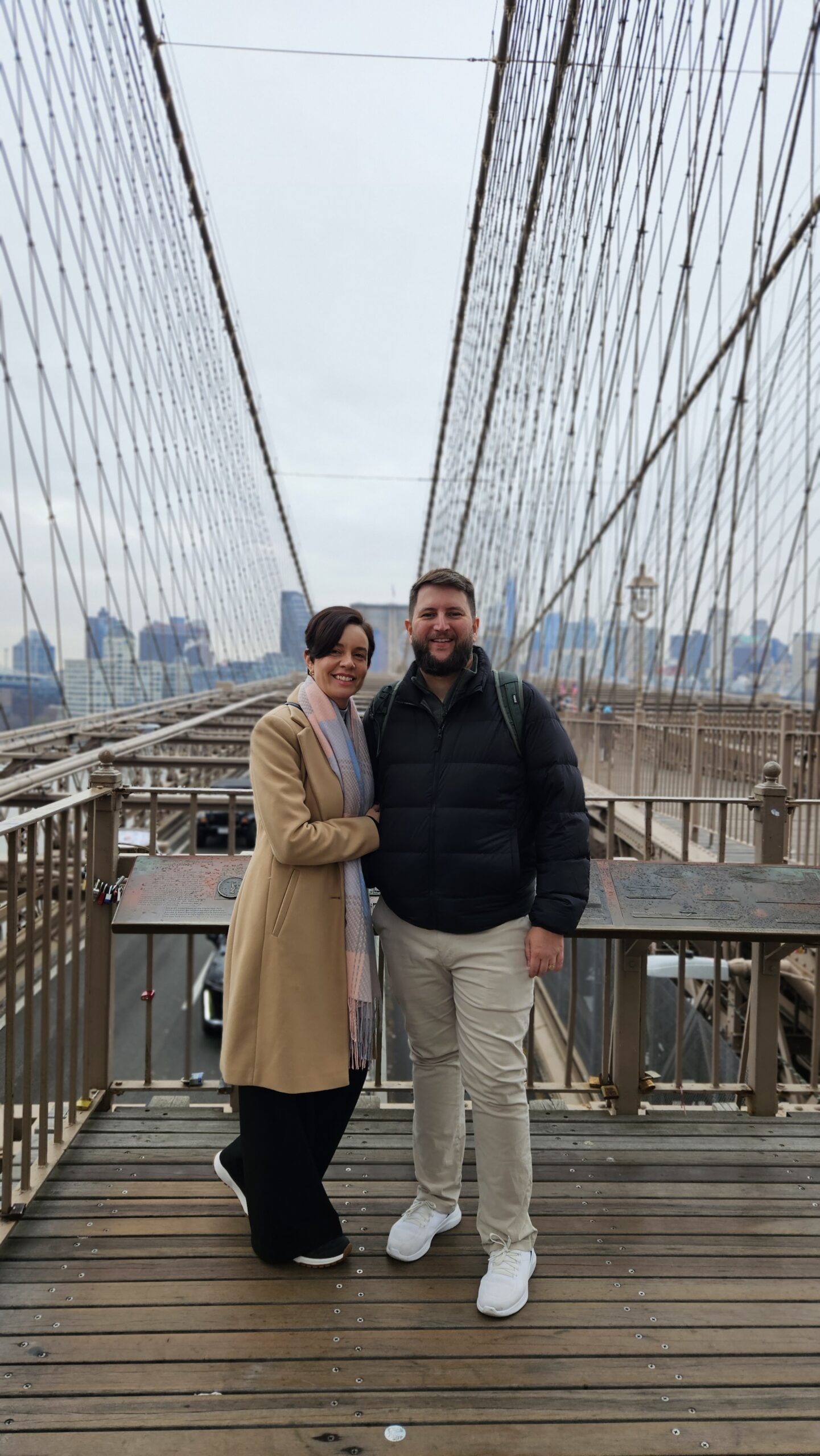 Casal na Ponte do Brooklyn com o skyline de Nova York ao fundo