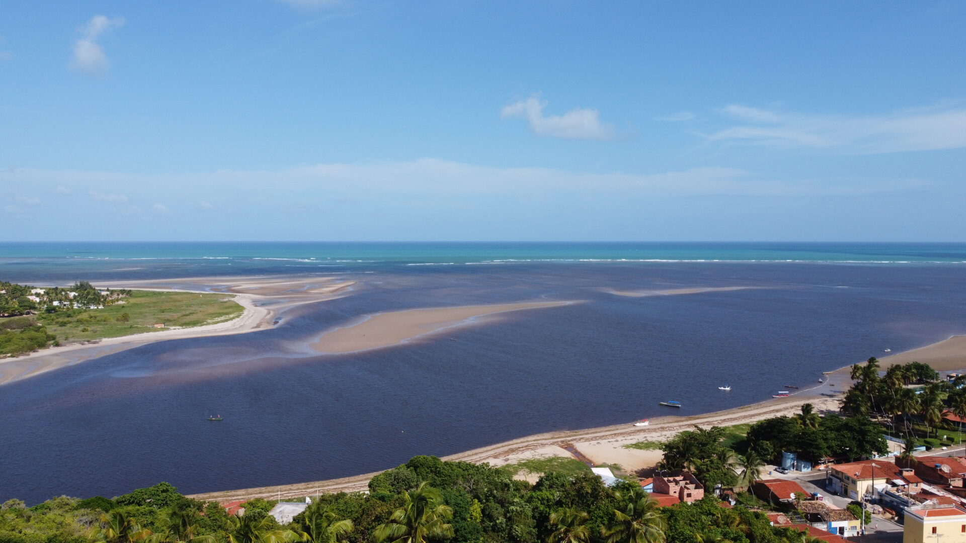 Vista aerea da foz do Rio Manguaba encontrando o mar em Porto de Pedras, Alagoas, com faixas de areia expostas na mare baixa