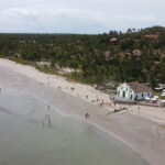 Vista aérea de drone da Praia dos Carneiros com a igrejinha branca e verde na areia