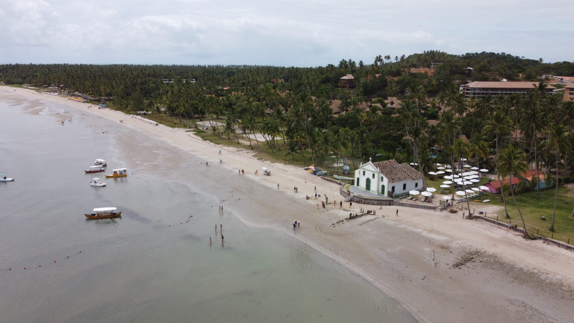 Vista aérea de drone da Praia dos Carneiros com a igrejinha branca e verde na areia