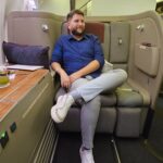 Rudi sentado na suíte de primeira classe da Qatar Airways rumo às Maldivas