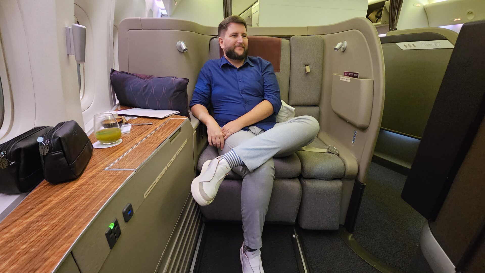 Rudi sentado na suíte de primeira classe da Qatar Airways rumo às Maldivas