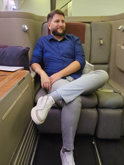 Rudi sentado na suíte de primeira classe da Qatar Airways rumo às Maldivas