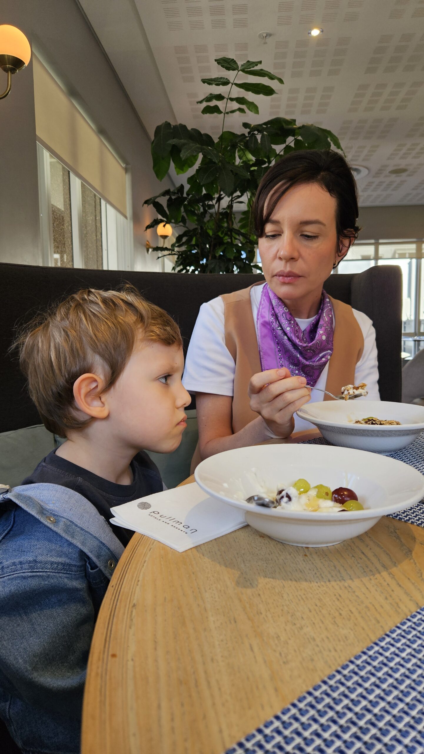 Mãe e filho tomando café da manhã no restaurante do Pullman Cape Town City Centre