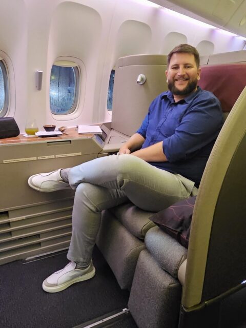 Rudi sorrindo na Suite 1K da Primeira Classe da Qatar Airways