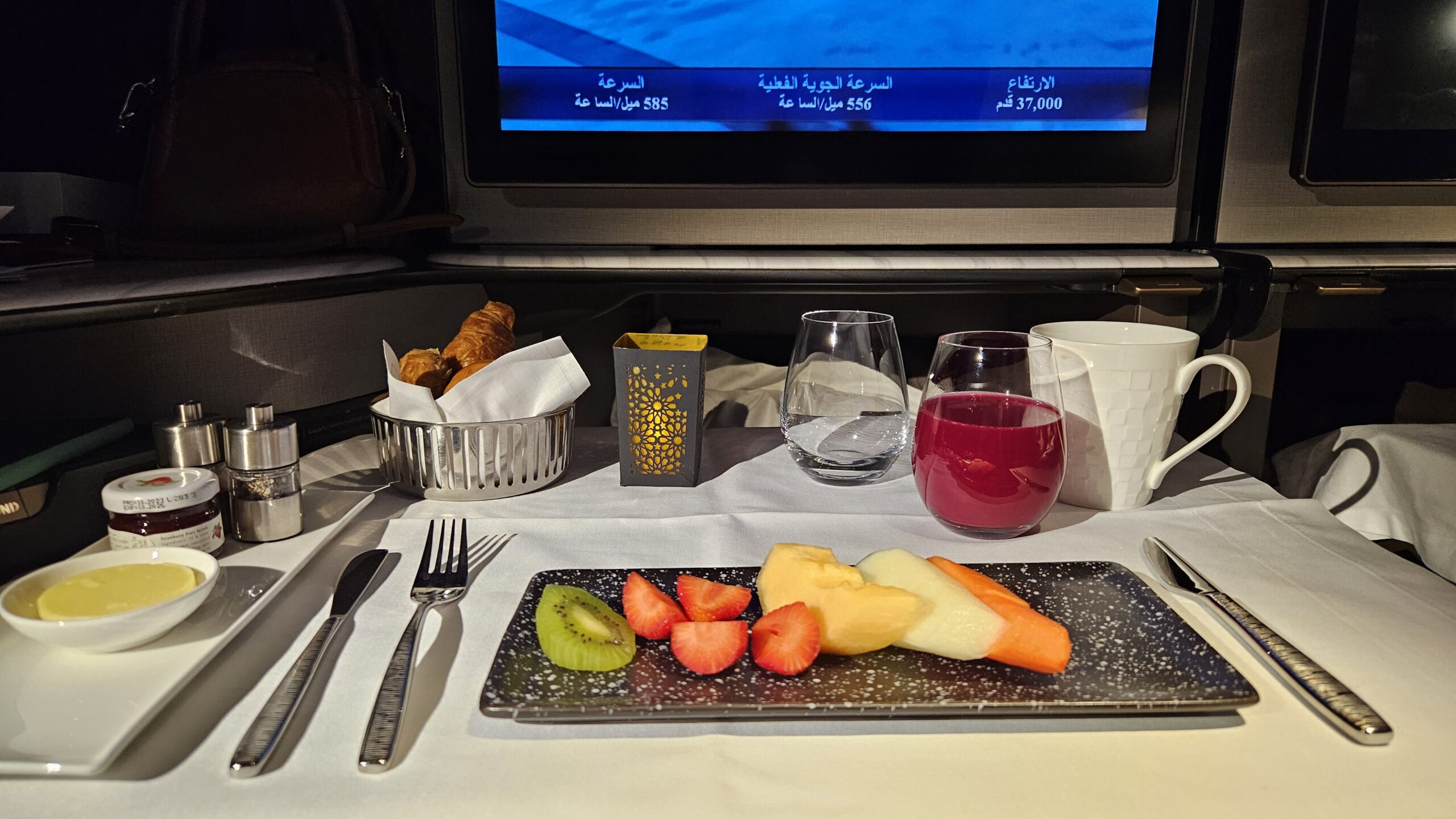 Bandeja de café da manhã da Qsuite com prato de frutas frescas, pães e suco
