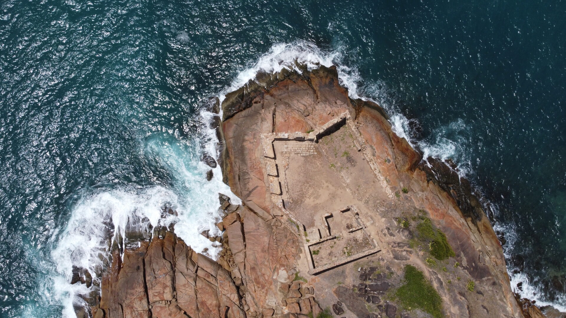 Vista aérea de drone de ruínas de forte histórico na costa perto do Recife