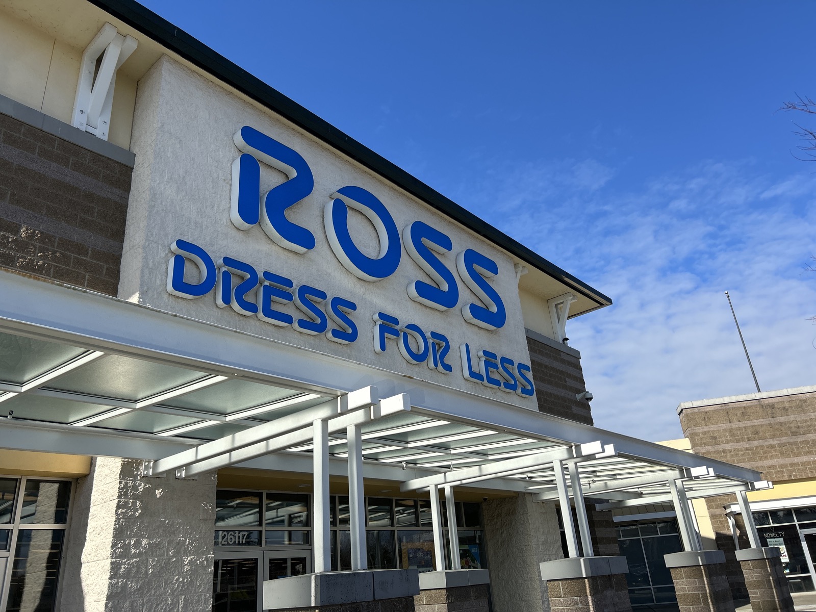 Fachada de loja Ross Dress for Less com letreiro azul e ceu azul